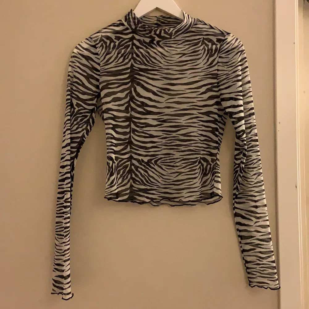 Säljer min croppade zebra mesh tröja från Gina tricot💕 tröjan har en liten krage med krusad kant på ärmarna och vid bottnen! Köparen står för frakt!. Toppar.