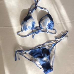 En bikini i blått tie dye/batik-mönster💙 överdelen är storlek 38 och underdelen är storlek 34 men efter som det är en knyt-design så är den mer flexibel i storlek💙 använd max 2 gånger men självklart ordentligt tvättad!! Finns inga fläckar eller slitage 💙 frakt ingår ej utan kostar 42kr💙 priset är för både överdel och underdel💙skriv om det finns några frågor💙