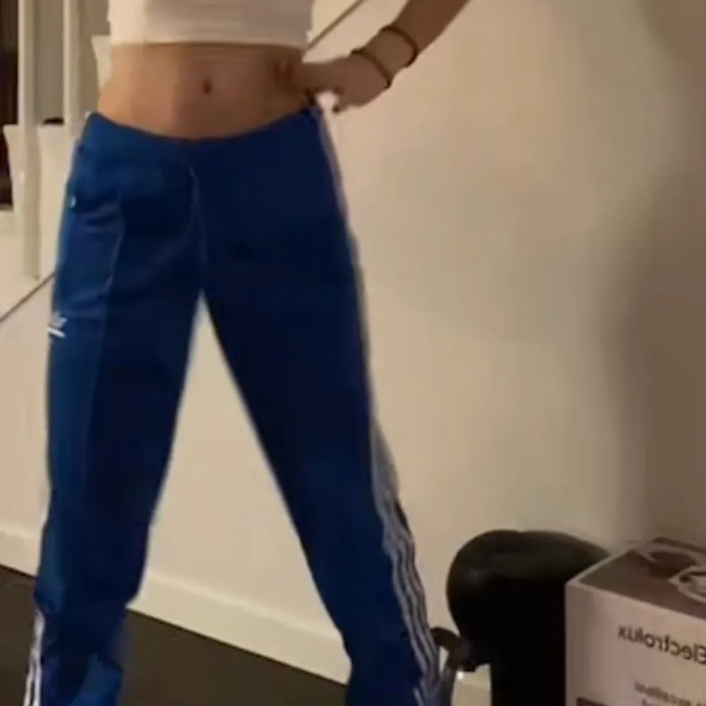 Säljer mina adidas-trackpants (vid bra bud). Jättefina byxor som jag köpte på adidas hemsida för 529kr någon gång i slutet av sommaren. Använt ett flertal gånger men abslout inget som märks. Är ca 1,64 och dom går över skorna. Har en dragkedja längs ner vid benet, som man kan välja om man vill ha som en ” slits ” eller stängd. Tar inte emot bud under 200kr. Vid frågor, fler bilder eller bud skriv privat. ❤️‍🩹. Jeans & Byxor.