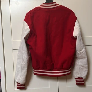 Baseballjacka röd - Baseballjacka med armar i läder från Frathouse Apparel. Köpt secondhand men kommer inte till användning så mycket då jag redan har en liknande. Möts gärna upp för köp i Stockholm annars står köparen för frakten💓