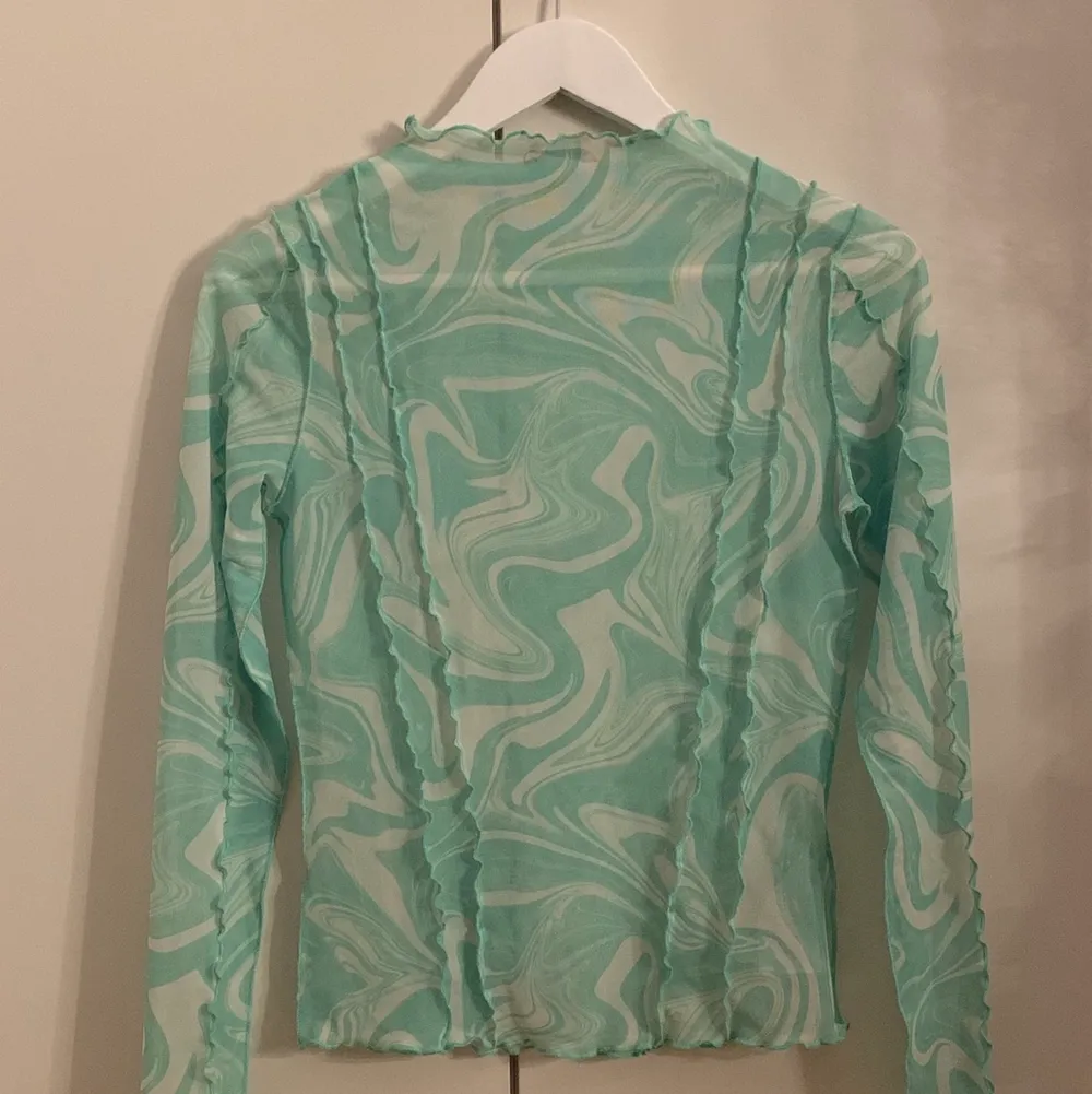 Säljer denna långärmade tröjan som är genomskinlig, köpte tröjan för ett tag sen men har tyvärr inte fått någon användning av den. Majoriteten av tröjan ser typ blå ut på bilden men den är grön och vit i verkligheten🤍 Kontakta mig vid intresse!. Tröjor & Koftor.