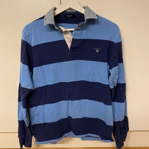 Blå Rugbytröja GANT - Säljer en blå GANT rugbytröja i stlk S. Köpt för 1199kr i GANT butik. Inte använd så mycket, bra skick. Jag står inte för postens slarv.