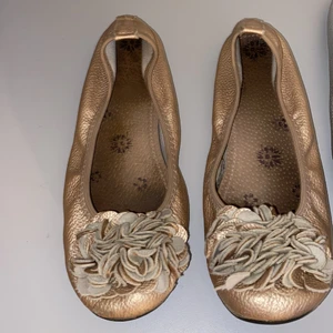 Ballerina skor  - Säljer guldiga ballerina skor för 50kr. Dom är ganska mycket använda men tycker ändå dom är i fint skick. Dom är i storlek 38 och jag kommer inte riktigt ihåg vart dom e köpta