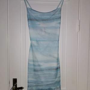 Tight ljusblå klänning med asymmetrisk kjol. Endast provad, prislappen är kvar. 