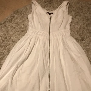 Vit klänning - En vit klänning med V urringning samt en kedja som går rätt igenom är det jag säljer :) Har hatten i några år och vill gärna bli av med den.