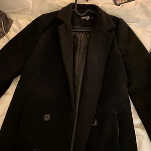 Trendig kort svart kappa - Säljer denna supersnygga korta trendiga kappan!! Helt oanvänd då den var för liten för mej. Den är i strl L men är absolut som en M. Väldigt trendig jacka nu för tiden kort och stilren! Köparen står för frakt❤️❤️