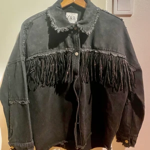 Svart Zara jacka med glansiga fransar - En fin jacka från Zara med glansiga fransar. Jackan är slutsålt på Zara.  Använt bara dåtal gånger. 
