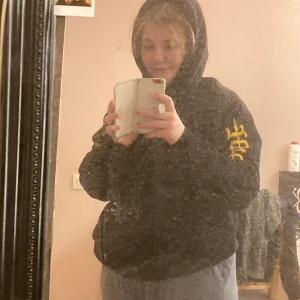 Svart hoodie från H&M - En svart hoodie med ett tryck på armen och baksidan samt en liten text på framsidan. Hoodien är från kallavfettningen i storlek M. Köpt 2020. Som ni ser så har trycket börjat lostna lite men det är inget som syns. Däremot så är ens mudden lite sönder (kan skicka fler bilder). Säljer den då den typ är för liten och inte min stil alls längre.