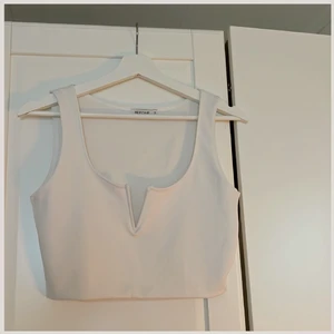Vit Topp - Söt vi topp från Nelly.com i strl S, köpt för ca 250:-🤍. Har ett litet grått märke (synbart på bild nr 2 vänster sida) vid bröstet. Gråare färg på vänster sidan av V- ringningen som också är knappt synbart. Använd 2-4 gånger, köpare betalar för frakt💗