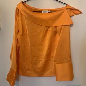 Orange satinblus från NA-KDS kollektion med Andrea Hedenstedt. Blusen är i storlek 34 och sitter väldigt fint över ena axeln🌼🌼
