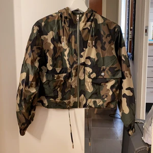 Tunn jacka  - Tunn militärjacka med luva, inte använd. Strl. S. Katt finns i hemmet. Frakt betalas av köparen 