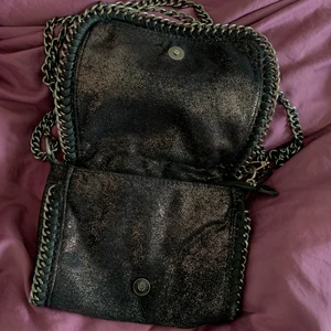 Axelväska (fest) - Festväska i Stella McCartney stil. Både knapp + dragkedja för att stänga och bra med plats för plånbok, mobil, laddare etc. Avtagbar axelkedja.