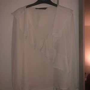 Blus från Zara i xs  - En benvitt blus från Zara med volanger som knappt är använd. Slutsåld topp på zara. 