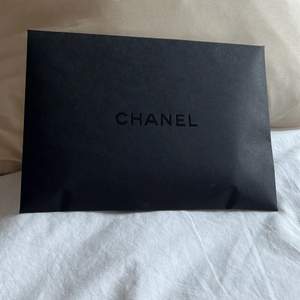 Svart kuvert med Chanel på, B 21,5 cm L 15,5 cm. Givetvis oanvänt.