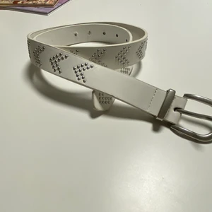 Vitt bälte från Lindex stl S - Köpte detta superfina skärp från Lindex. Det är vitt met metall prickar som bildar spetsa/pilar. jag har klippt mer hål så att man kan spänna skärpet hårdare. Tyvärr har jag inte använt skärpet mycket då jag slutade använda skär lite efter jag köpte detta, den är alltså nästan i nyskick. Mitt pris är 50 kr. Vild frakt betalar köparen frakten. Kan hämtas i Mjölby, Mantorp eller Motala. Betalas Via swish.