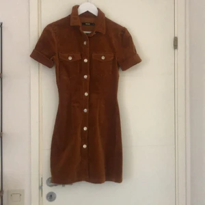 Manchester klänning  - Brun/orange  klänning i manchester från bikbok. Använd enstaka gånger. Skriv för fler bilder. Köparen står för ev. frakt.