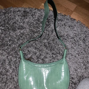 Grön väska💚 - Säljer min gröna fina väska då den inte kommer till användning, den har bara änvöngs ett fåtal gånger och är som ny👍🏼denna väska är mitt emellan stor. 