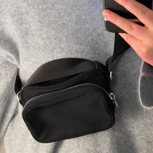 Weekday sund crossbodybag - Säljer denna snygga crossbodyväskan ifrån Weekday i nylon. Inköpt för ett drygt halvår sedan och är bara använd ett fåtal gånger sedan dess. Väskan har två fack och ett justerbart band. Nypris 269kr