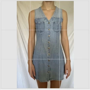 Jeansklänning - Den perfekta retro jeansklänningen. Knappar hela vägen upp med en snygg V-urringning. Ett spänne i ryggen för att framhäva midjan. Fungerande fickor. Äkta jeanstyg. Använt flera gånger men har växt så den börjar bli för kort på mig. Den har storlek XS men fungerar på mig som var S.