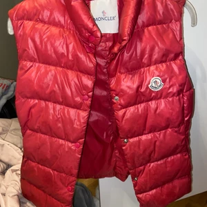 MONCLER VÄST - En så fin väst som är rosa/röd💓 Köpt för lite mer än 2 år sen i Paris. Har tyvärr inga äktesbevis, men givetvis äkta!! Rätt så bra kvalite men tanke på att den är rätt använd men har inga skador på tyget!!💓💓 NYPRIS: ca 7500kr
