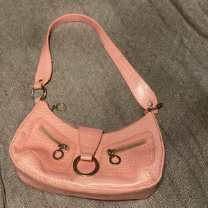 Söt väska  - Rosa liten Axel väska som e söt till sommaren, har två fack inuti. Ett lite större med dragkedja å ett mindre som e öppet, även ett fack på baksidan med dragkedja 