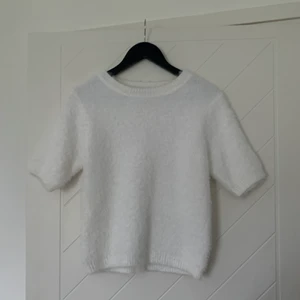 Stickad topp - Vit stickad kortärmad topp i nyskick, använd kanske 1,2 gånger. Stretchigt material i storlek S-M. (Fraktkostnad ingår ej)💗💗