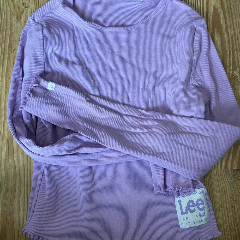 En lila tröja från hm i samarbete med Lee, säljer den då jag inte använder den . T-shirts.