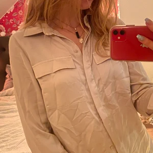 satin skjorta strl 38 - bech/guldig skjorta från h&m, använd 3-4gånger, lite skrynklig. nypris ca 100-200kr