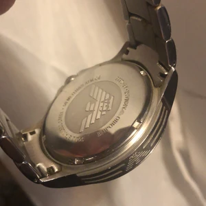 Emporio Armani AR0636 Chronograph - Jätte fin herrklocka använd ett fåtal gånger. Det ända som fattas är boxen. Men den är äkta och det kan ni kolla upp via modell nummer mm. Säljer den nu då den känns alldeles för tung och klumpig för min del,den har legat i en klockbox så ett byte av batteri är nödvändigt. Min make avled förra året och han var sjuk i 2 1/2 år så den är i ett jätte fint skick. Inga skambud tack!