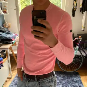 En sjukt snygg rosa tröja från SuperDry Surf CO men läckert litet märke på vänster axel. Köpte den för några år sedan men hamnade tyvärr längst in i garderoben då jag inte vågade använda denna coola tröja vilket jag ångrar idag. För nu är den för liten. Detta innebär att den är i nyskick. Jag har vanligtvis stl M och det är datorföretaget den sitter lite tight på bilden. Kan skickas men köparen står för fraktkostnaden.