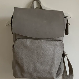 Grå ryggsäck från Don Donna - Jättefin ryggsäck som knappt används förutom ett par få gånger. Ryggsäcken har två fack på utsidan och två stora och fyra små på insidan. Parfekt ryggsäck att ha med till skolan/jobbet om man vill ha en väska med mycket utrymme men även att en lite finare. Priset kan diskuteras.