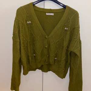 Kort kardigantröja med blommor - Jättefin kort kardigan med fina broderade blommor. Liten i Storlek (jag är vanligtvis XS/S och gillsr pösiga kläder så M passade perfekt). Priset går att diskutera. 