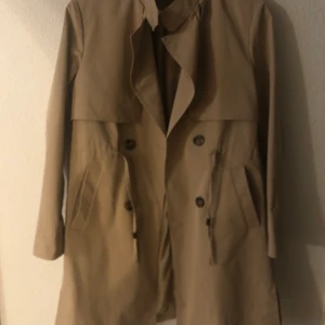 Trenchcoat - Beige trenchcoat. Knappt använd. Står att det är XL men passar mer som en S eller XS. Pris kan diskuteras!Köparen står för frakt!
