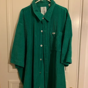 Manchester skjorta  - Skjorta i Manchester från Collusion. Färgen ser mer ”ärtgrön” ut i verkligheten, inte så turkos som på bilden. Oversized. 