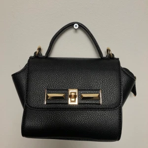 Liten väska  - Fin liten väska, knappt använd. Långt band medföljer. 