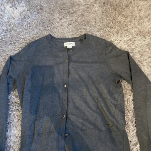 Kofta från Lindex strl M - Mycket fin grå kofta från Lindex med guldiga knappar!💛🖤 Strl M men passar även fint på dom som har strl xs/s. Använd fåtal gånger. Säljer då det inte är min stil! Köpt för 399kr!