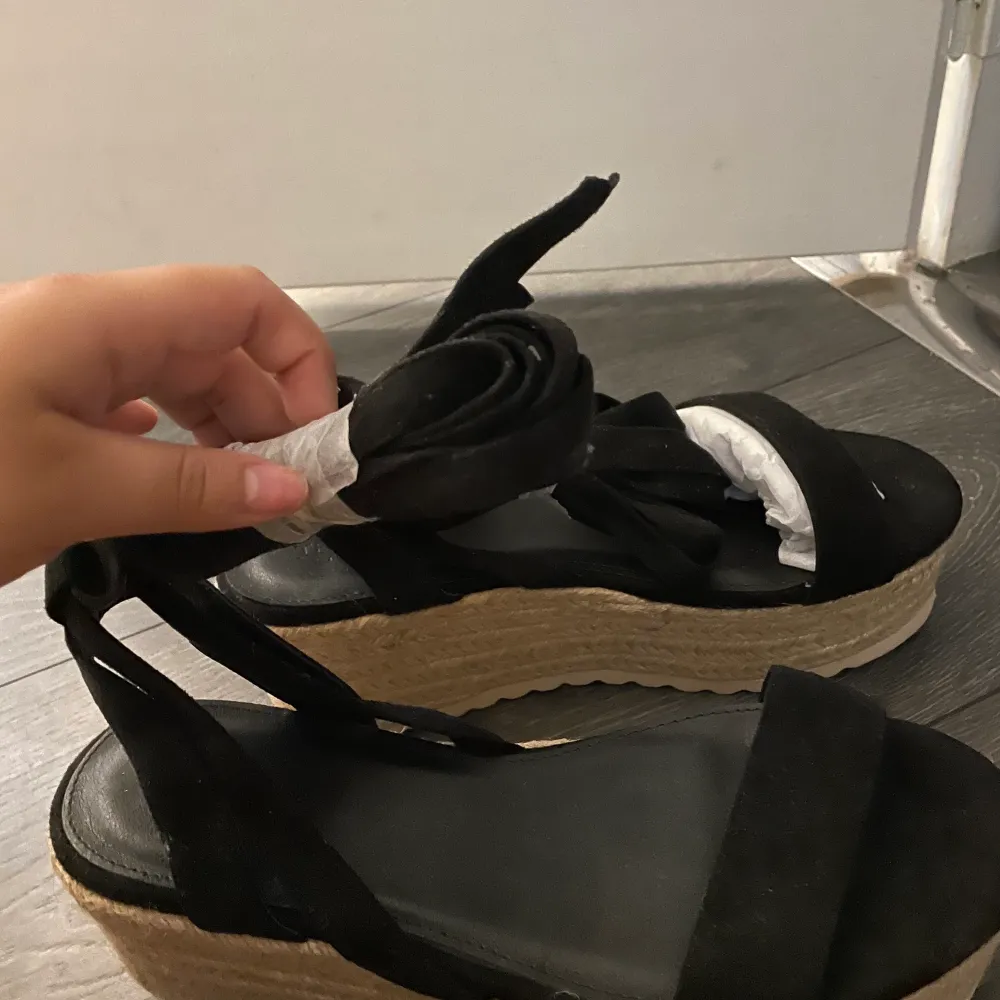 Svarta flatform- sandaler med knytning runt benet. Skorna är inköpta i mars 2021 från ASOS - Truffle Collection för 490kr. Skorna är helt oanvända! (Bild tagen från ASOS för att visa skorna bättre) . Skor.