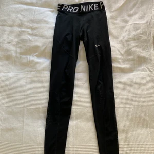 Svarta Nike Pro träningstights - Svarta Nike Pro träningstights. Enbart använda ett fåtal gånger och i jättebra skick! Storlek S men passar både XS och M skulle jag tro. Nypris: 400kr