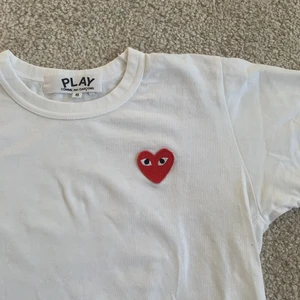 CDG t-shirt storlek S - Vit t-shirt från COMME des GARÇON i storlek S, liten i storleken så passar även XS beroende på hur man vill att den ska sitta. Väldigt sparsamt använd, säljer då den tyvärr är för liten. Djur & rökfritt hem. Nypris ca 1000kr. Köparen står för frakt 🤍🤍🤍🤍