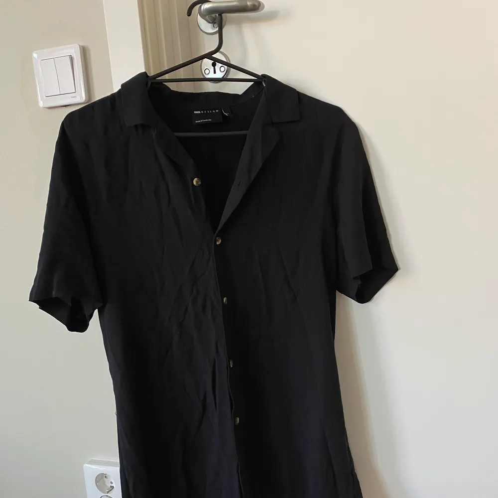 En vanlig svart skjorta som är från herrsidan på ASOS. Den är i storlek small men eftersom den är från herr så ör den oversized. Skitsnygg att ha uppknäppt över ett vitt kroppat linne och vanliga jeans. Säljer för kommer inte till användning längre men är i toppenskick! Köparen står för frakt 📦 . Paidat.