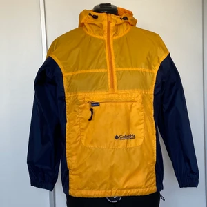 Vintage Columbia Vindjacka - Gul och blå vintage vindjacka från Columbia med ficka på magen. Säljer pga använder aldrig längre. Nypris runt 800kr