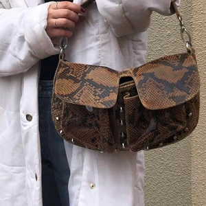 Väska - Ormskinns mönstrad väska! Från Unlimit bags! Använt ofta. Den har inga specifika slitningar. Överaskande Rymlig väska. Säljer då den inte kommer till så mycket användning för min del längre. 