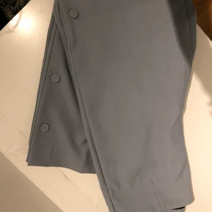 Blåa byxor Zara med knappar - Ett par så fina blåa byxor från Zara med knappar på sidan av benet. Aldrig använda! Kan frakta och mötas upp!!☺️