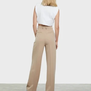 Beige kostymbyxa  - En beige kostymbyxa från BIKBOK som är långa i storleken.  