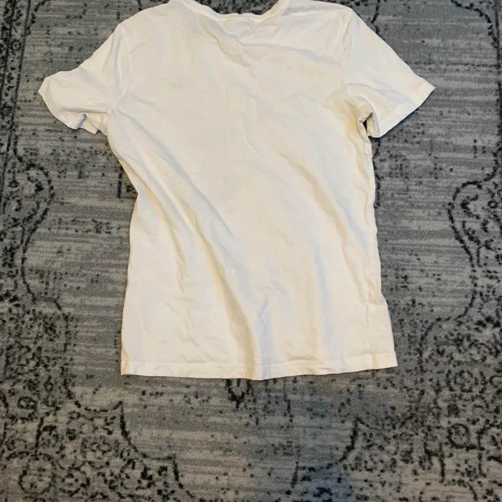 En vit fila tröja med broderat märke på framsidan. Köpt på junkyard förra sommaren. ☎️🧿. T-shirts.