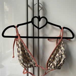 HM x Love Stories Bikini - Super fin knappt använd Bikini topp med rosett snörning på axlarna Strl 42. Helt oanvänd Bikiniunderdel i strl 42. (Kan köpas separat)