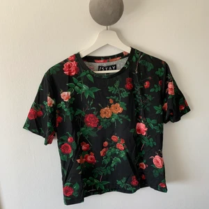 Blommig t-shirt - En fin, något kortare T-shirt! Aldrig använd😆