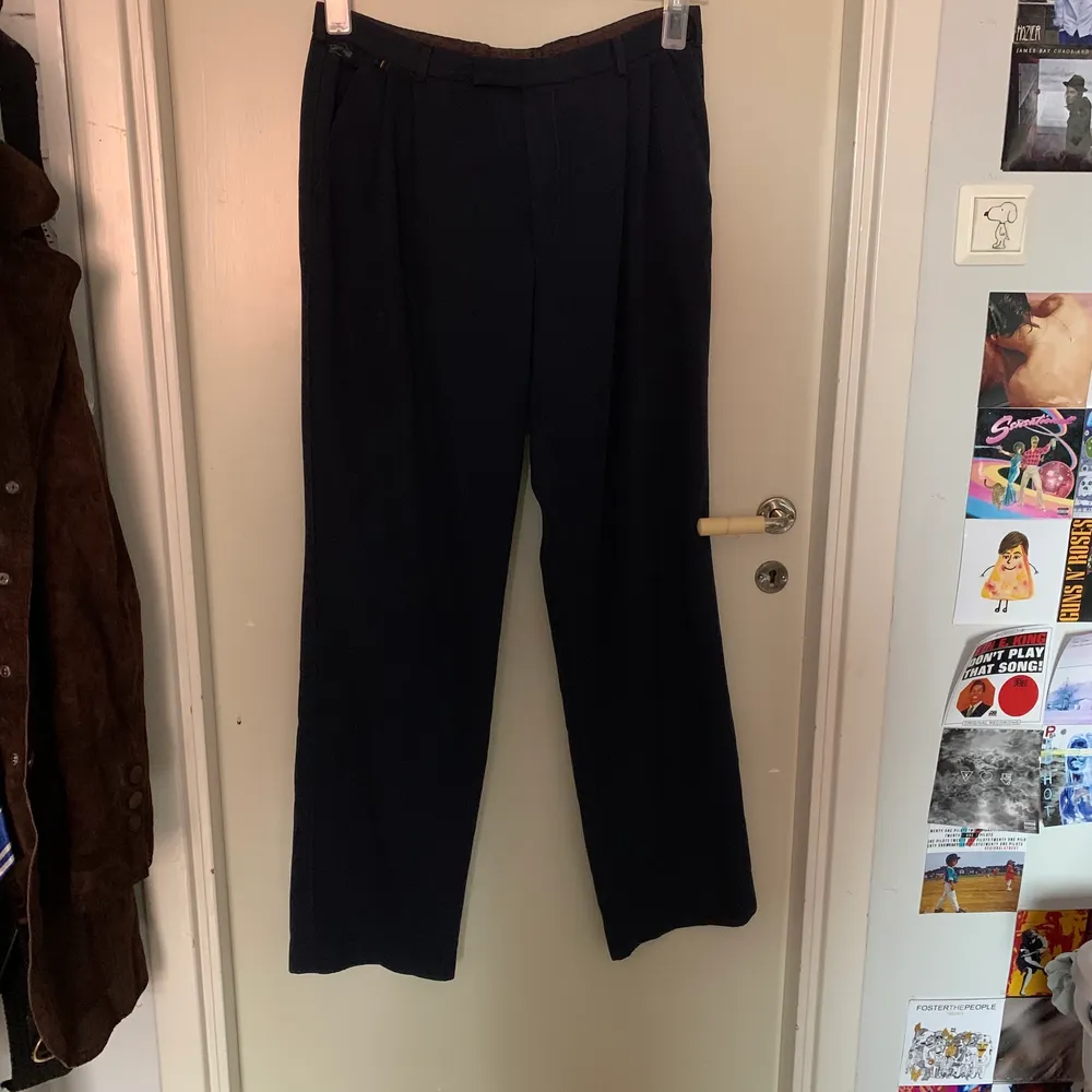 Mörkblåa byxor, tre stycken fickor. Skulle gissa på att dom är från 80-talet med tanke på detaljer. Passar bäst S/M. Jeans & Byxor.