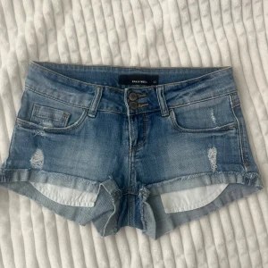 Blå lågmidja jeansshorts  - Snygga blå jeansshorts från Tally Weijl med slitna detaljer. Storlek 34/XS!