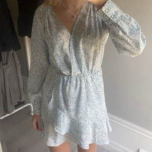 Klänning - Super fin blå vit klänning med små blommor och volanger! Endast använd fåtal gånger då den inte heller ha några defekter💞 postar fort!